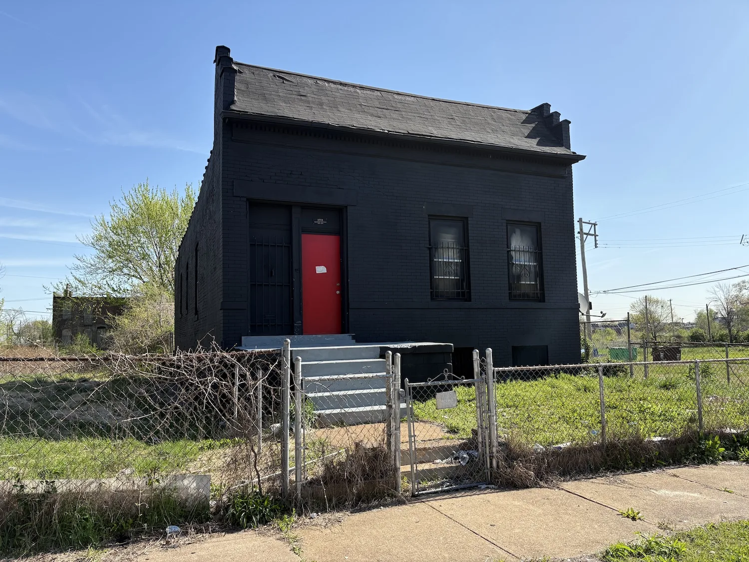 A home on Maffitt Avenue with black-painted brick and a red door.