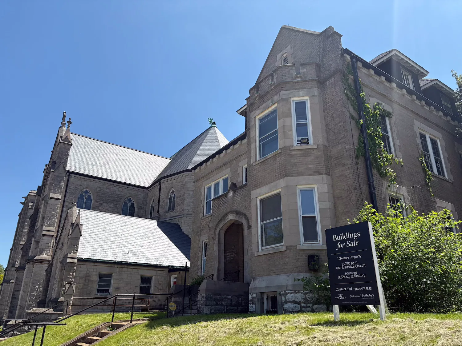 The former Immaculate Conception/St. Henry rectory is in the foreground, with the church building in the background.