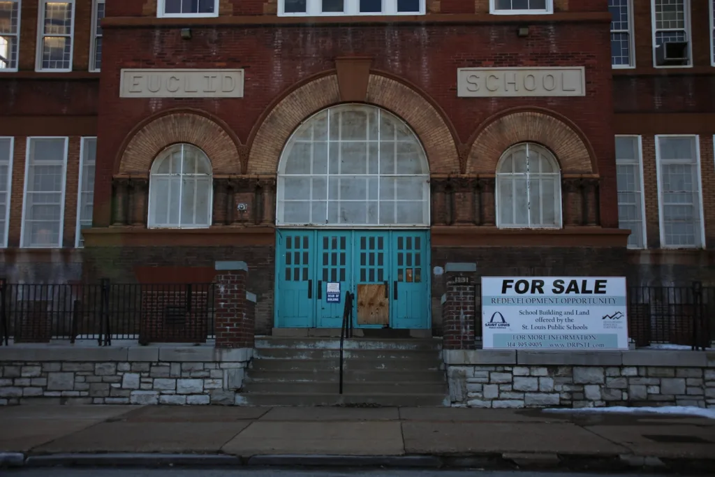 A school with a for sale sign.